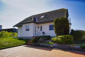 una casa bianca con tetto nero di Ferienwohnung mit Terrasse in ruhiger Lage - Haus Südperd FeWo Strandwinde a Thiessow