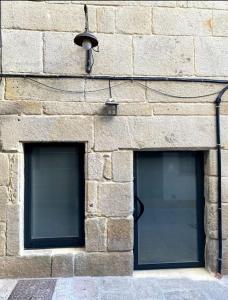 two windows on the side of a brick building at Casas da Bríxida. Apartamento accesibel in Cangas de Morrazo