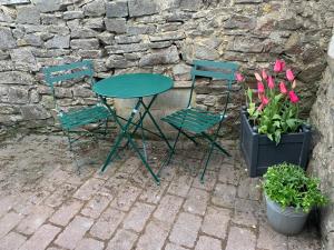 a table and two chairs and some plants and flowers at Counting Sheep in Great Longstone