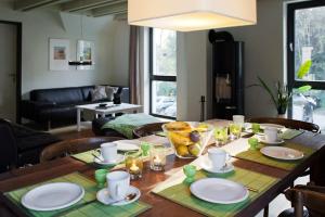a wooden table with plates and dishes on it in a living room at Wellness- FeWo "Akelei" mit Sauna & Kamin in Zingst