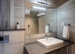 y baño con lavabo blanco y espejo. en Yaya Hotel & Apartments, en Nairobi