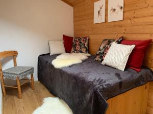 Cama pequeña en habitación con silla en Lilly Chalet- Apartments with private sauna, close to ski lifts en Bad Kleinkirchheim
