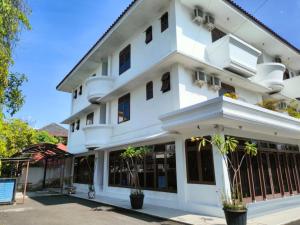 ein weißes Gebäude mit Pflanzen davor in der Unterkunft Wisma Hari Kota in Medan