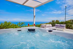 bañera de hidromasaje con vistas al océano en Villa del Drago, en Scopello