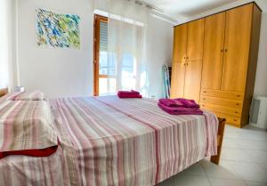 1 dormitorio con 1 cama con 2 toallas rosas en Artist Alguerhouse en Alghero