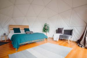 a bedroom with a bed and a chair in a tent at Beavers Retreat Glamping in Tenby