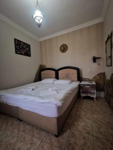 1 dormitorio con 1 cama grande con sábanas blancas en Anz Guest House Pansiyon en Selcuk