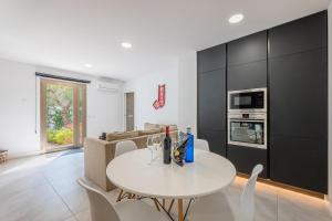 uma sala de jantar branca com uma mesa e cadeiras brancas em Bonanova 20 em Palma de Maiorca