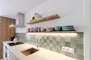 una cucina con lavandino e piastrelle sul muro di StayatSas Luxe App vlakbij strand, 80 m2 terras, grote zwembaden Marbella a Marbella