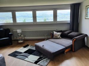 a living room with a couch and a large window at Ferienhaus Bellevue in Öhningen