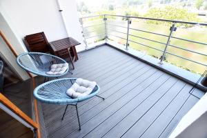 balkon z dwoma krzesłami i stołem w obiekcie Apartamenty NAVIGATOR-Rezydencja Portowa 14 w Kołobrzegu