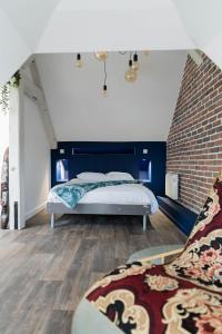 a bedroom with a bed and a brick wall at Doux Cocon Tropical au cœur du centre ville in Troyes