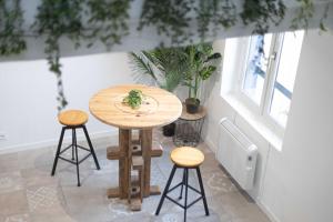 a wooden table with two stools in a room at Doux Cocon Tropical au cœur du centre ville in Troyes +27 photos