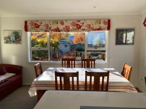 een eetkamer met een tafel en stoelen en een raam bij Amazing Aubrey, walk to Bremner Bay in Wanaka