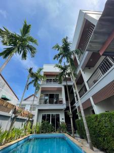 a hotel with a swimming pool in front of a building at Vivi Boutique Room Hotel SHA Plus in Rawai Beach