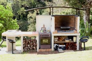 - une cuisine extérieure avec une cuisinière et une table dans l'établissement La Rond'Dada, à Sainte-Suzanne