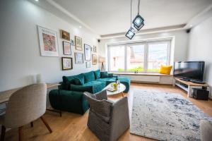 uma sala de estar com um sofá verde e uma televisão em Spacious and Bright 2BDR Apartment in the Old Town em Sarajevo