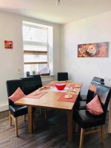 uma mesa de jantar com cadeiras pretas e uma mesa de madeira em Ferienwohnung Seenrunde 