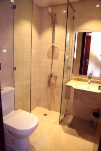 a bathroom with a shower and a toilet and a sink at Al Bostan Al Masi Hotel in Mecca