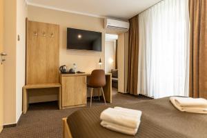 Hotel Boss في لودز: غرفة فندقية بسريرين ومكتب