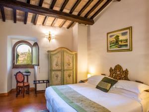 una camera da letto con un letto, una sedia e una finestra di Borgo Petroro a Todi