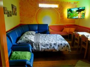 ein Wohnzimmer mit einer blauen Couch und einem Bett in der Unterkunft Krasberry in Komen