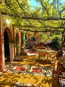 a patio with a table and chairs under a tree at Krasberry in Komen