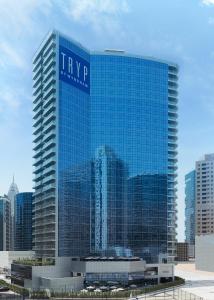 a tall building with a blue sky at TRYP by Wyndham Dubai in Dubai