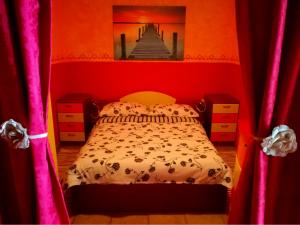 ein Schlafzimmer mit einem Bett in einem roten Zimmer in der Unterkunft Krasberry in Komen
