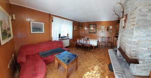 ein Wohnzimmer mit einem roten Sofa und einem Tisch in der Unterkunft Country House Aleš in Gornja Bistrica