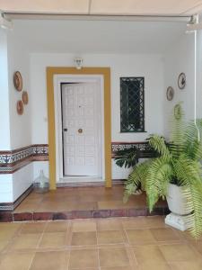 un corridoio con una porta bianca e una pianta di Casa adosada - Los Boliches - Fuengirola a Fuengirola