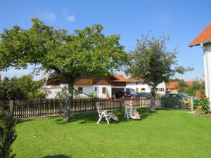 a yard with a fence and two chairs in the grass at Gästehaus Reisacher - Einzelzimmer in Peiting