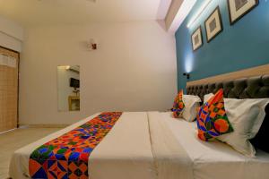 1 dormitorio con 1 cama grande con una manta colorida en FabHotel Royal Inn en Nueva Delhi