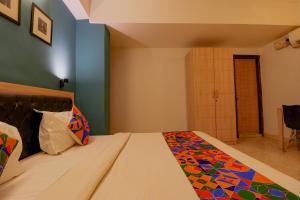 Un dormitorio con una cama con una manta de colores. en FabHotel Royal Inn en Nueva Delhi