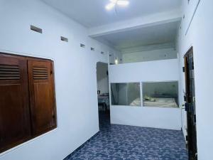 une pièce vide avec un lit et un placard dans l'établissement Jaffna RR Holiday Home Non AC, à Jaffna
