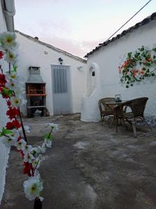 a patio with a table and chairs and a fireplace at La Romana in Escalonilla