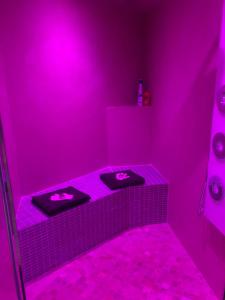 uma casa de banho rosa com dois lavatórios num quarto rosa em Appartement Love room avec jacuzzi et hammam privatisé Lieu insolite en amoureux Spa détente assurée avec de doux massages en options sur demande em Orgon