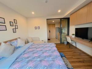 a bedroom with a large bed and a television at La Habana Huahin by Ying in Hua Hin