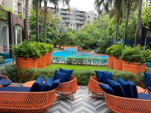 a garden with chairs and a pool in the background at La Habana Huahin by Ying in Hua Hin