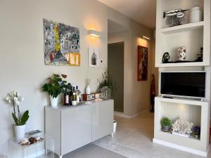 a living room with a tv and a white cabinet at Villa Luminosa in Torre del Lago Puccini