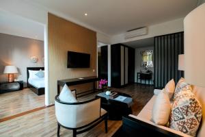 Una sala de estar con un sofá y una habitación con una cama. en The Lavana Akatara Villa Nusa Dua, en Nusa Dua