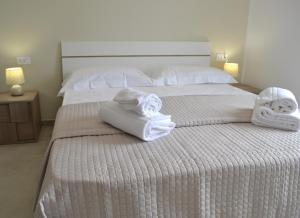sypialnia z 2 łóżkami i ręcznikami w obiekcie B&B Sole&Sale w mieście San Leone