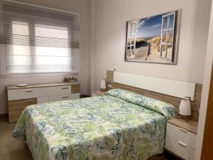 een slaapkamer met een bed en een foto aan de muur bij Bajo en primera línea de playa in Alcossebre
