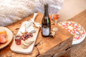 a wooden table with a bottle of wine and wine glasses at Oastbrook Glamping in Bodiam