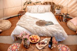 Oastbrook Glamping في Bodiam: غرفة نوم بسرير وطاولة عليها فاكهة
