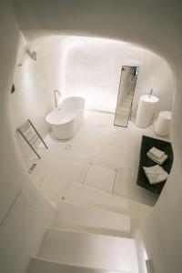 ein weißes Badezimmer mit einem Waschbecken und einem Spiegel in der Unterkunft Elegant Santorini Villa Villa Spyros Villa Demi Private Hot Tub Air Conditioning 2 Bedroom in Oia