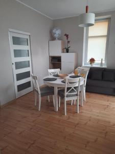 a kitchen and dining room with a table and chairs at Apartament Nowowiejskiego in Świnoujście