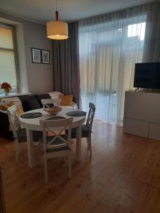 a living room with a table and a couch at Apartament Nowowiejskiego in Świnoujście