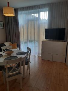 a living room with a table and a tv at Apartament Nowowiejskiego in Świnoujście