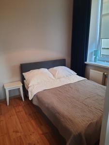 a bed in a bedroom with a table next to it at Apartament Nowowiejskiego in Świnoujście
